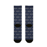 Back of Are We There Yet? ferry socks laid flat, navy repeating ferry pattern with black heels and toes