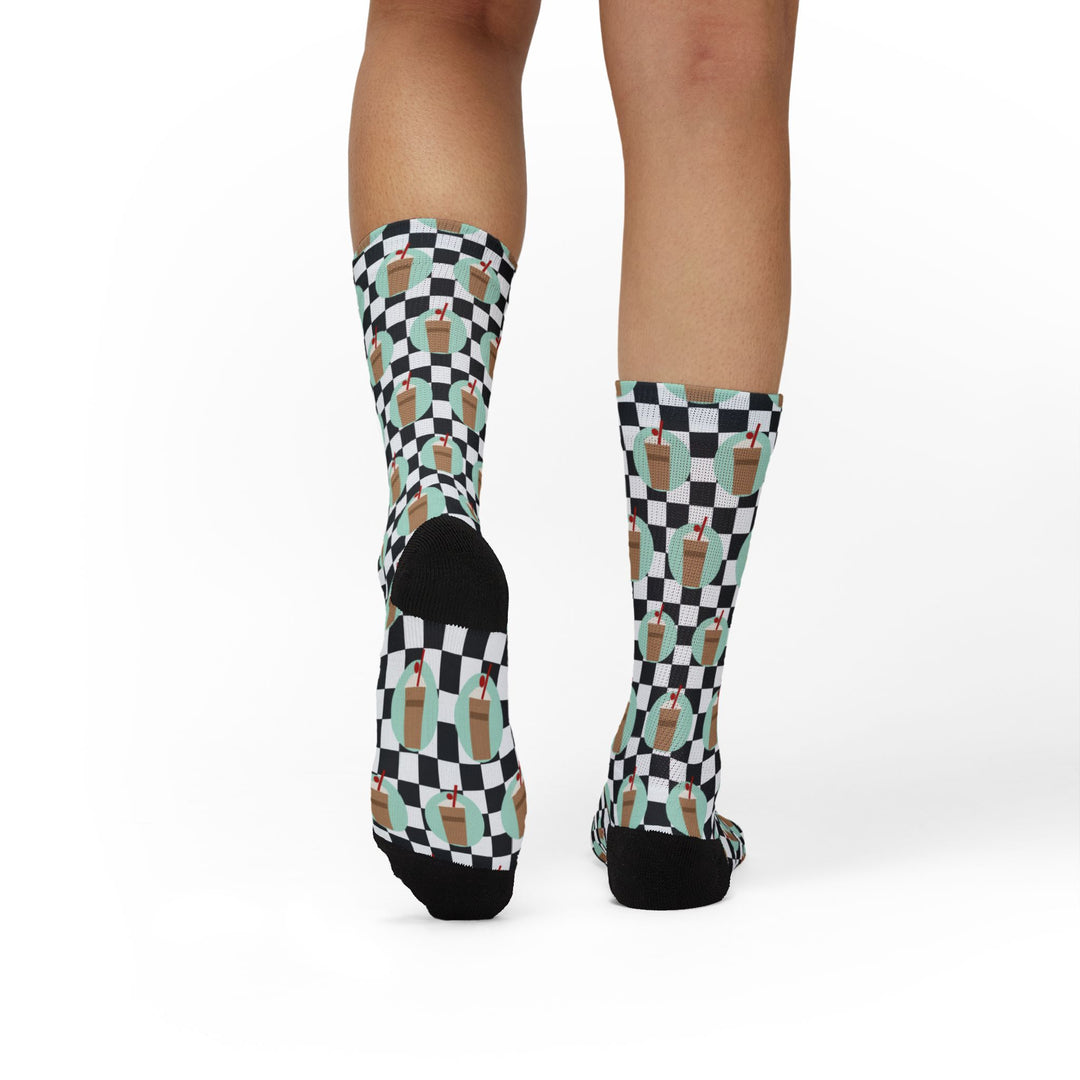 Model standing with back to camera in I'll Have a Cabinet Rhode Island socks, black heels above white-floor backdrop