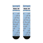 BlockBoundRI Seal of Approval Rhode Island socks, light blue with gray harbor seals and white slogan band, flat lay