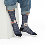 Model in rolled jeans seated on a white block in navy Are We There Yet? ferry crew socks
