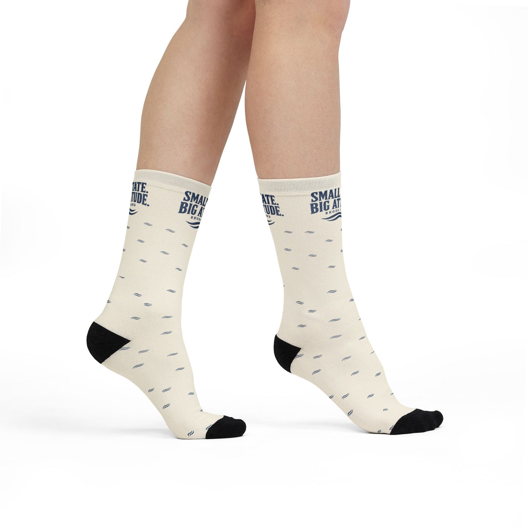 Model standing in white Small State. Big Attitude. Rhode Island socks with black heels and toes, angled view
