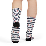 Rear view of a model mid-step in striped red anchor socks with black heels, Hold Fast nautical crew socks