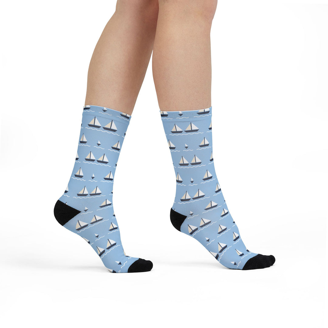 Model walking in light blue sailing socks with small white sailboats, side view with black toes