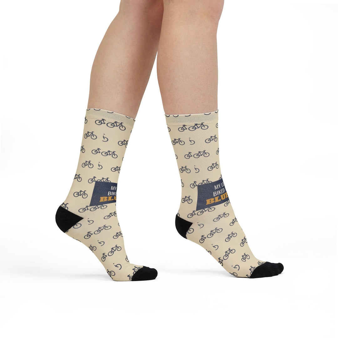 Model walking in My Legs Biked the Bluffs Block Island socks, front view of the navy slogan band