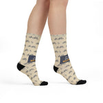 Model walking in My Legs Biked the Bluffs Block Island socks, front view of the navy slogan band