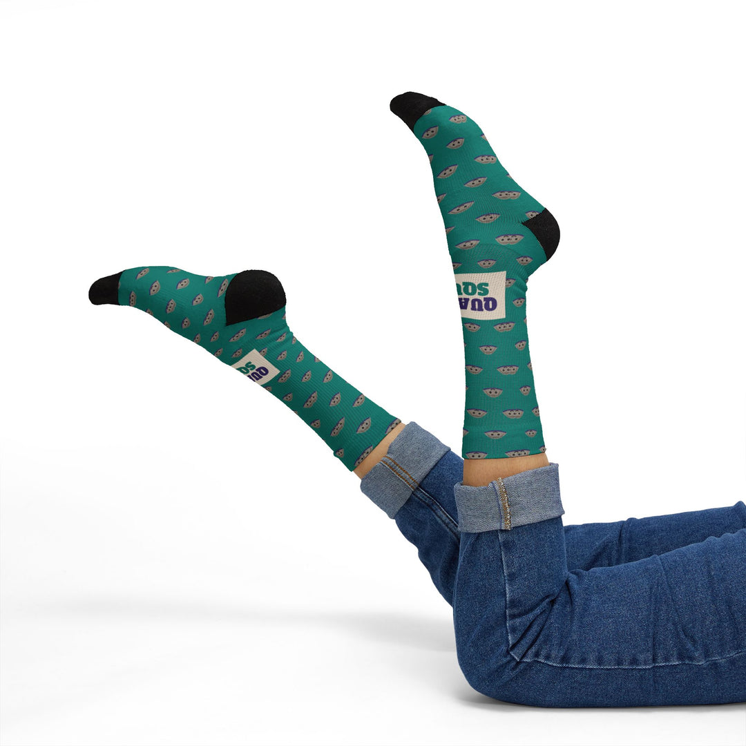 Model in blue jeans lying back, legs kicked up in teal Quahog Squad Rhode Island clam socks with black toes