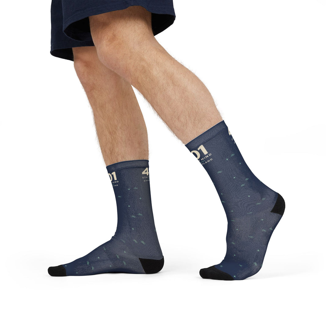 Side view of a walking model wearing navy Rhode Island crew socks with the 401 State of Mind cuff design