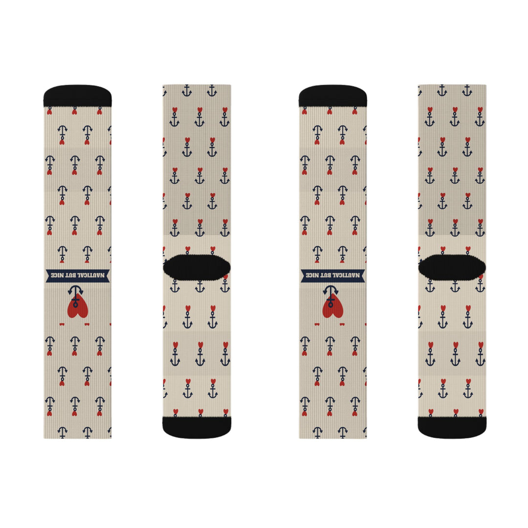Two pairs of tan Nautical But Nice anchor socks laid flat, front and back with navy banner and red heart