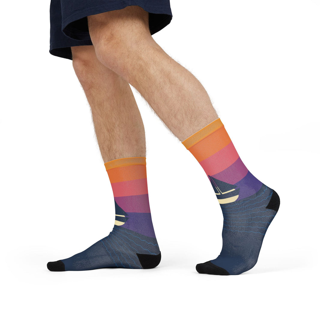 Model in navy shorts mid-stride in sunset gradient sailing socks with a white sailboat at the ankle