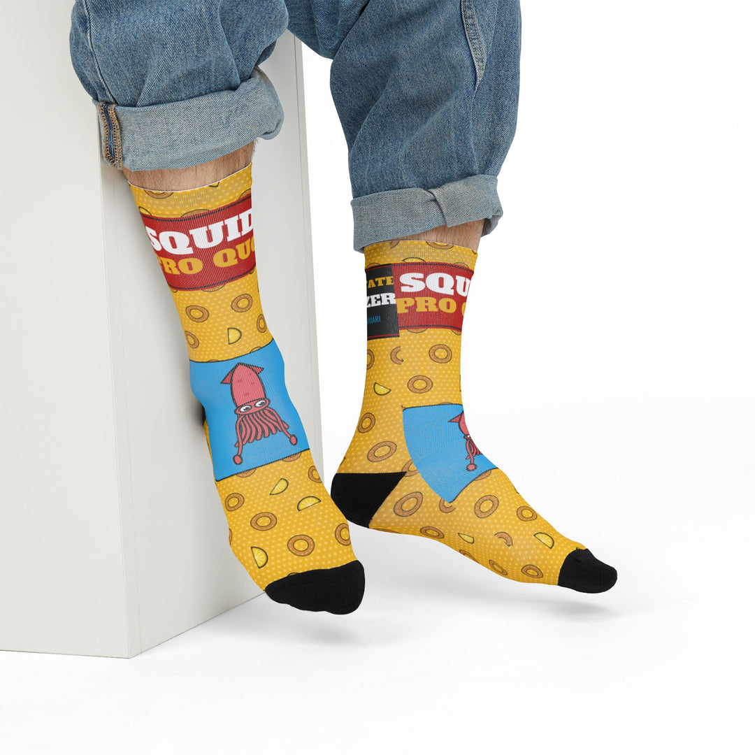Model in rolled jeans seated on a white block showing the red Squid Pro Quo band on yellow Rhode Island socks