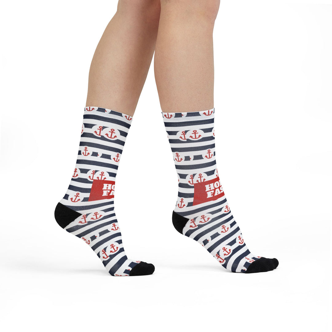Model walking in navy and white striped Hold Fast anchor socks, red Hold Fast panel on the side, nautical crew socks