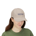 Woman in a green tee wearing the Stone Crossing Club Block Island hat, angled front view of embroidery