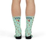 Standing legs in mint green Off Duty. On Island. socks showing the slogan and cocktail graphic on the shins