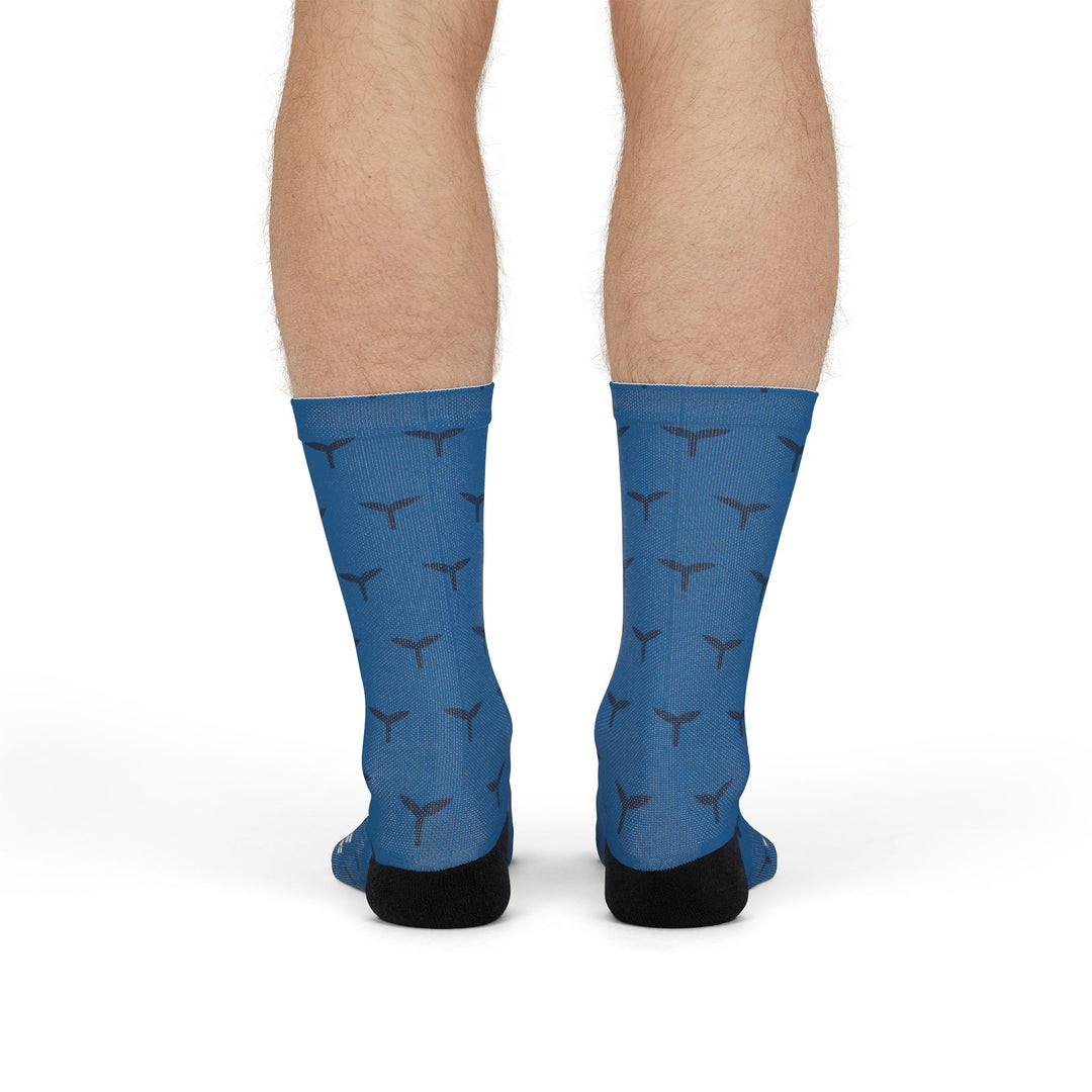 Model standing in blue Whale Hello There ocean socks, back view of the whale tail pattern and black heels