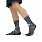 Model in navy shorts mid-stride wearing navy compass rose socks with gold Just Sailing lettering