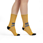 Model standing in mustard yellow I Like My Wieners All the Way Rhode Island socks, side view