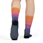 Back view of model wearing sunset sail nautical crew socks showing the orange-to-navy fade and dark heels