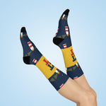 Lifestyle shot of crossed legs in Get Lit lighthouse nautical crew socks against a light blue background