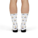 Front view of legs in white Smallest State Biggest Mouth Rhode Island socks with a gold star-ringed anchor print