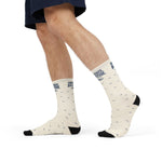 Side view of a walking model in white Rhode Island crew socks with Small State. Big Attitude. cuff and waves