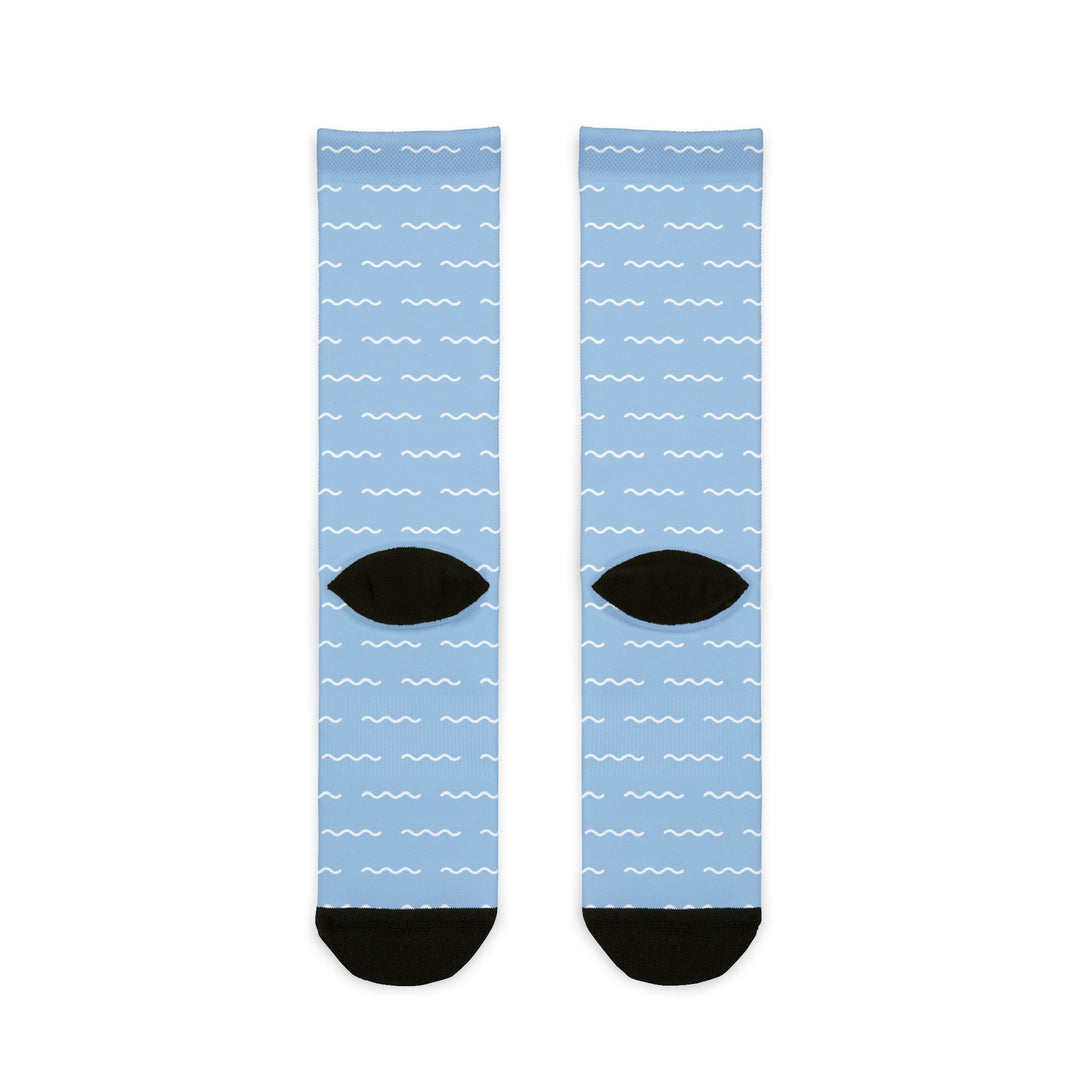Back of light blue Block Island socks flat lay showing white dash pattern and black heels and toes