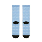 Back of light blue Block Island socks flat lay showing white dash pattern and black heels and toes