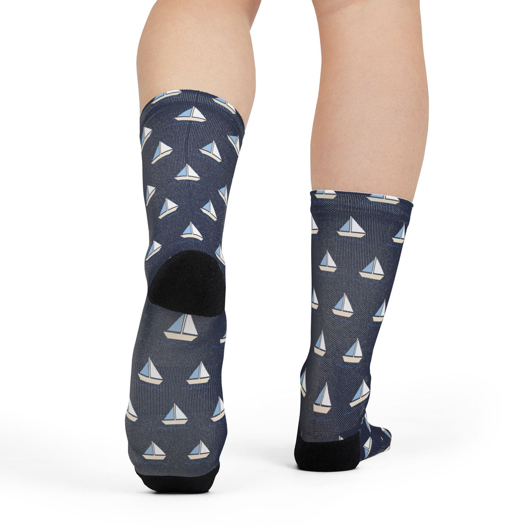Rear view of legs in navy sailboat-print Captain of the Couch socks showing the black heels