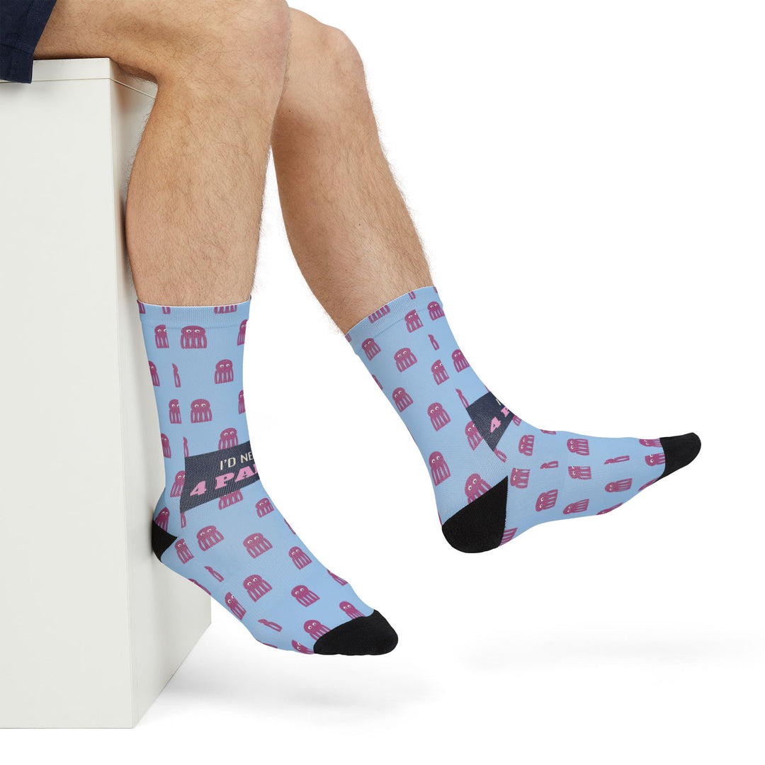 Seated model stretching one foot out in light blue funny ocean crew socks with pink octopuses