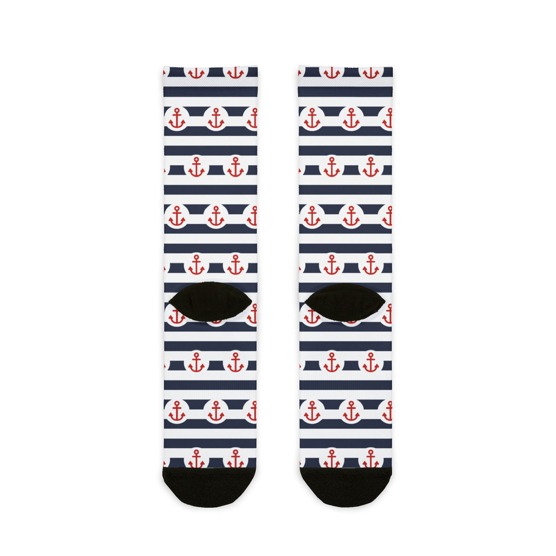 Back of the navy-striped anchor socks laid flat showing black heels and toes, red anchor nautical crew socks