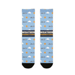 BlockBoundRI Weather Permitting Block Island socks, light blue with ferries, clouds and suns, front flat lay