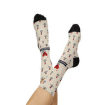 Legs raised and crossed in tan Nautical But Nice nautical crew socks with navy banner and red heart