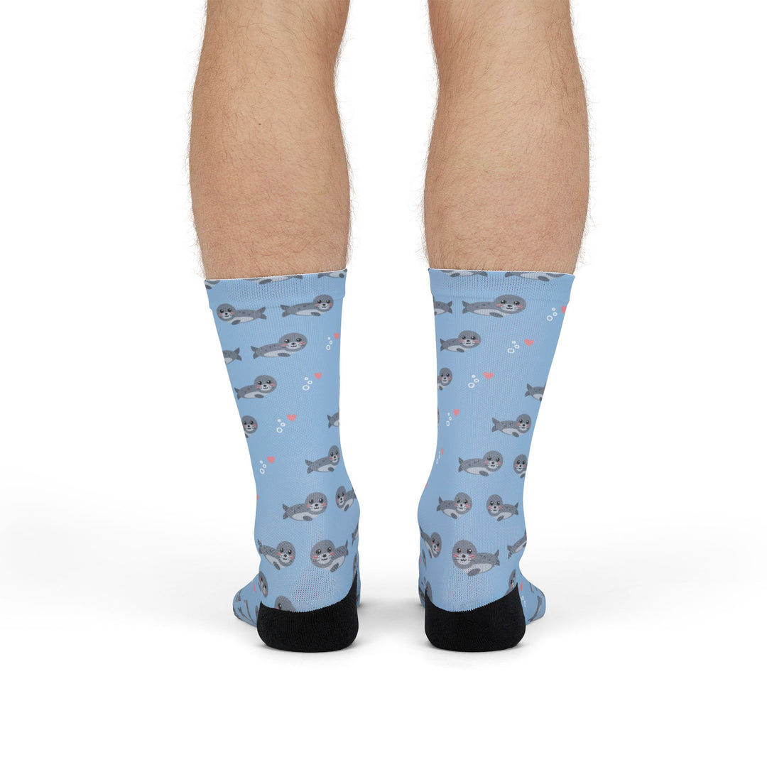 Front view of legs in light blue harbor seal funny beach socks with black heels and toes