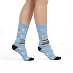 Model standing with crossed feet in light blue Weather Permitting ferry socks with orange suns