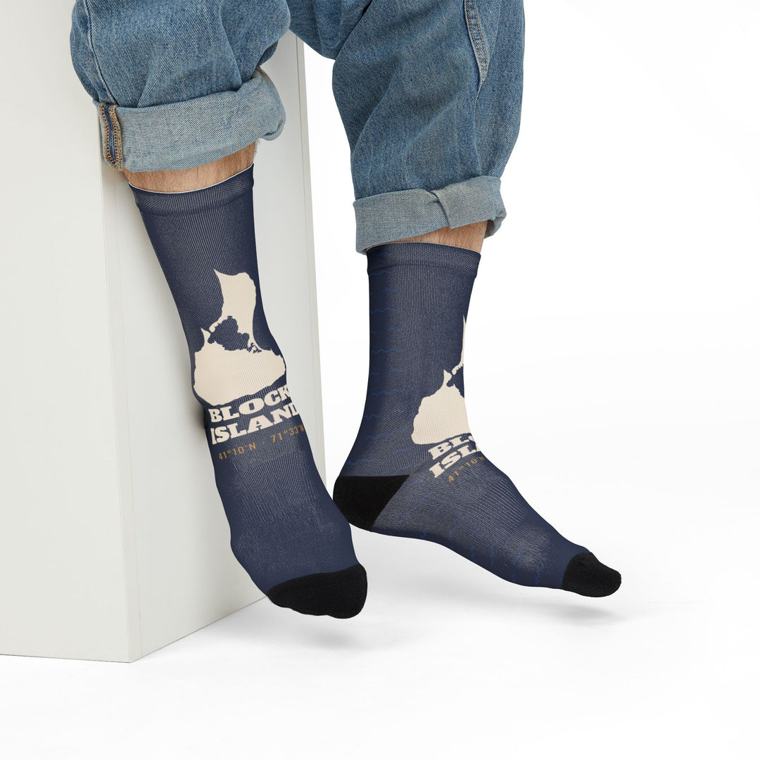 Seated model in rolled jeans showing the cream island outline on navy Block Island crew socks