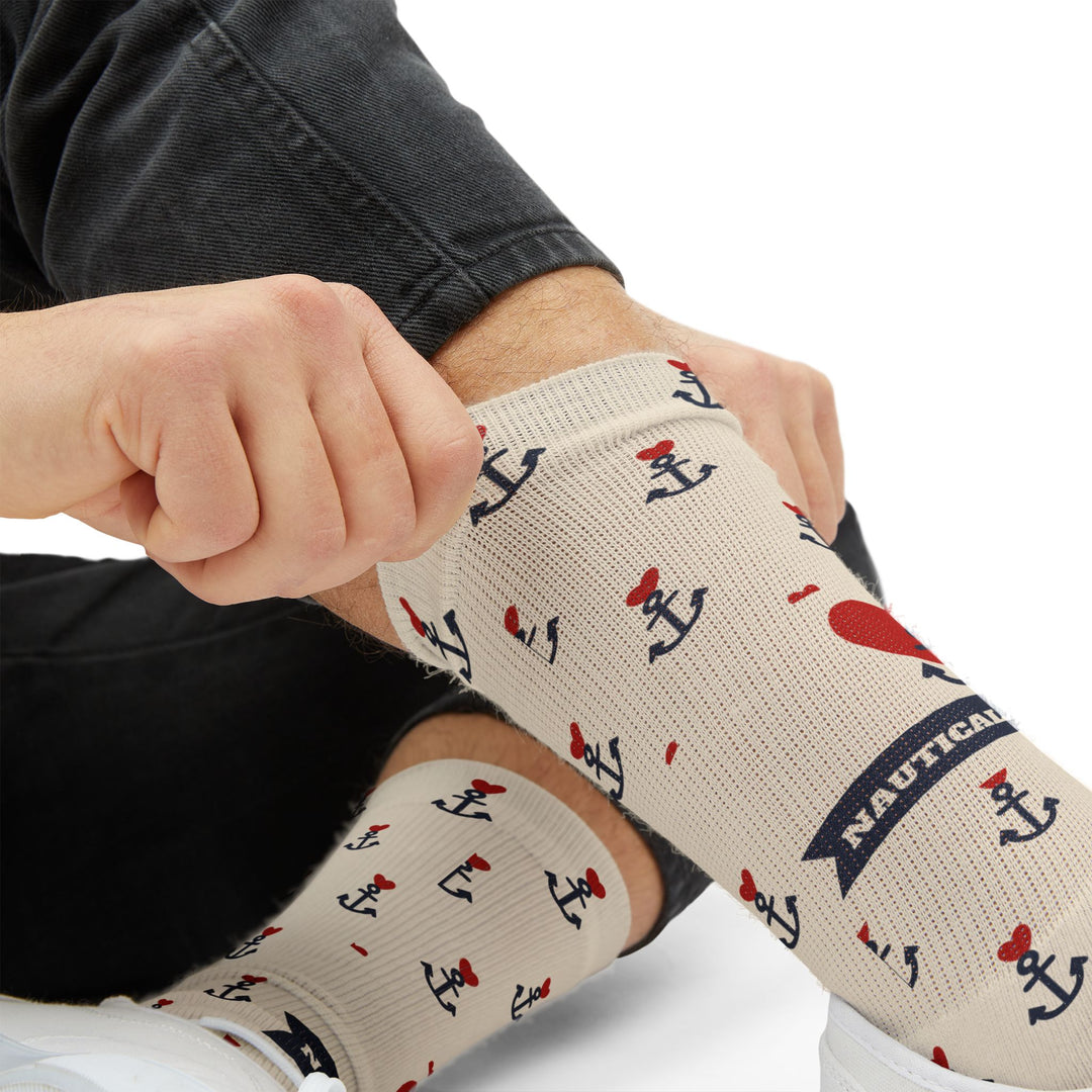 Close-up of the navy Nautical banner and red heart anchor tattoo on tan crew socks being pulled on