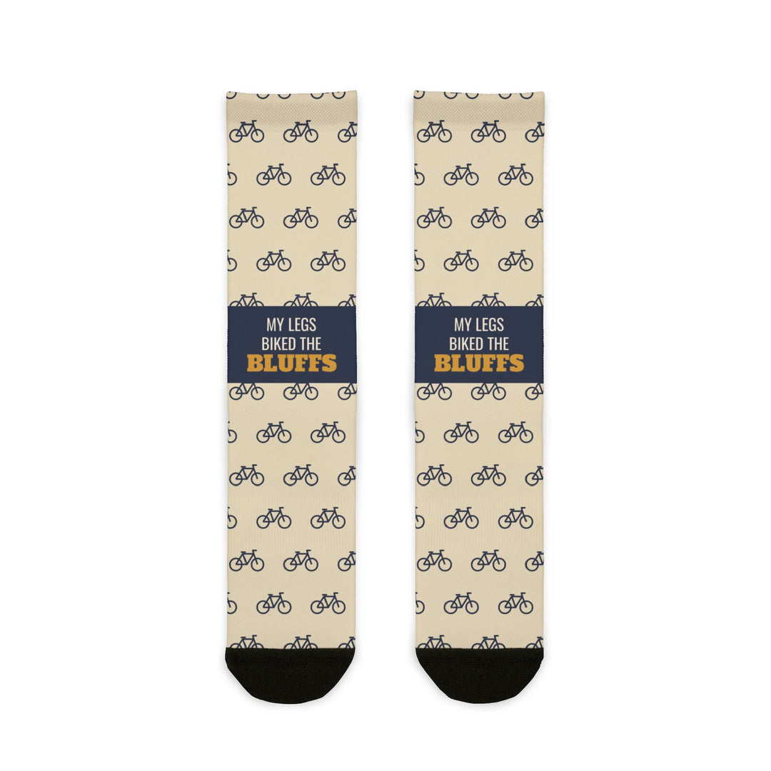 My Legs Biked the Bluffs Block Island socks laid flat: cream crew socks with bicycle print and a navy slogan band
