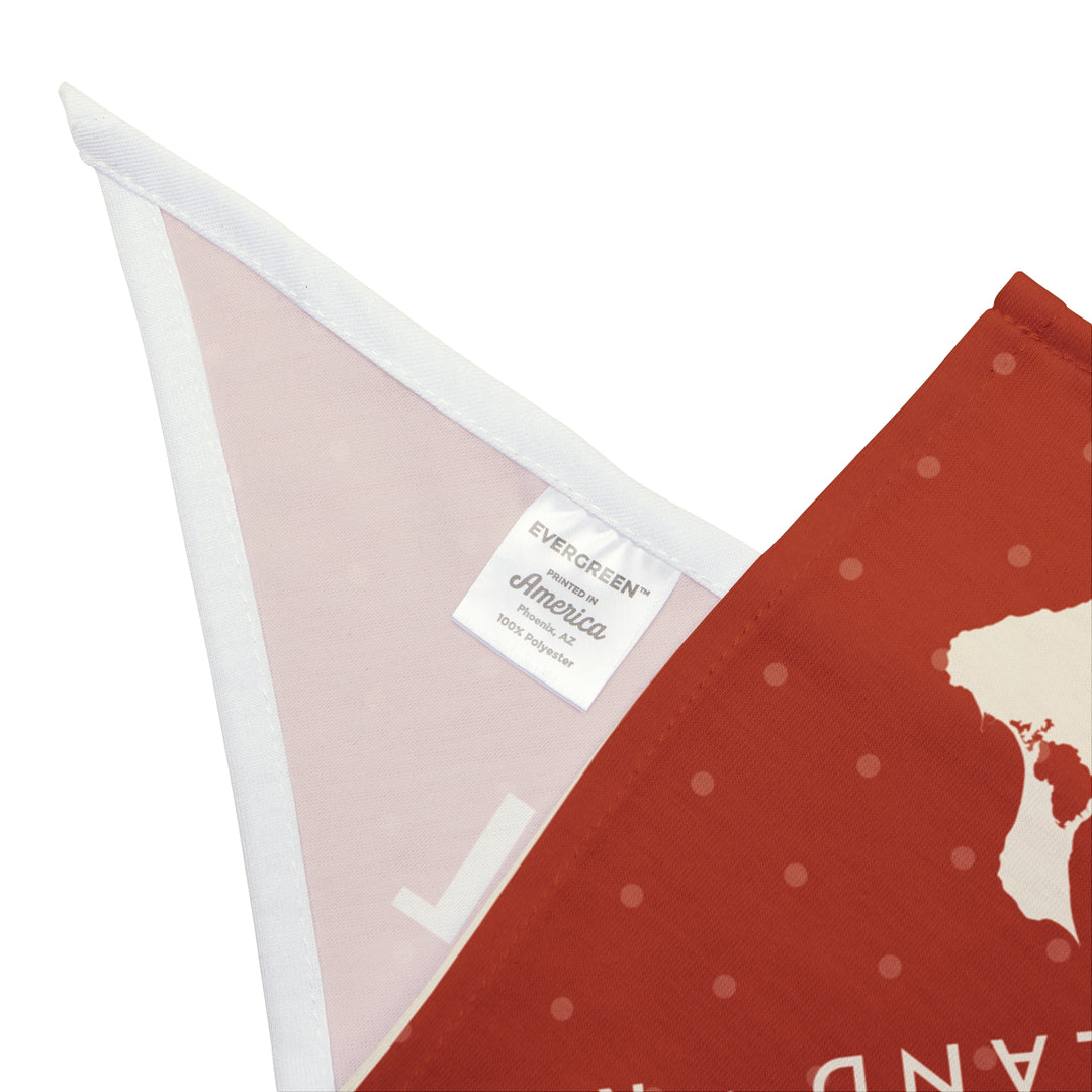 Corner close-up of the Beach Patrol Block Island bandana showing red dotted print, white trim and care label