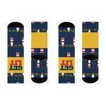 Flat lay of both Get Lit nautical crew socks front and back, navy with lighthouses and a yellow GET LIT band