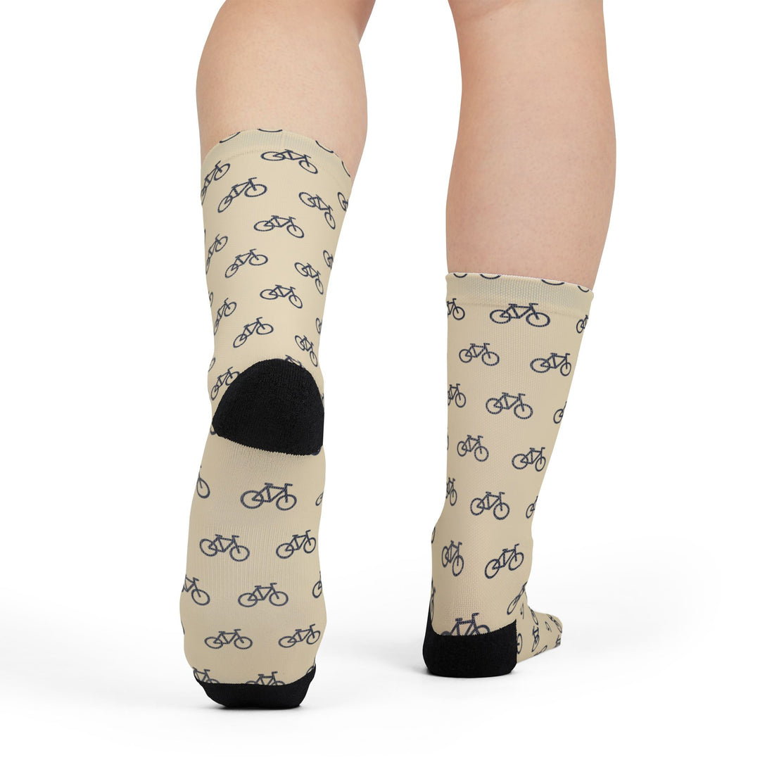Rear view of a model in cream My Legs Biked the Bluffs bike crew socks with black heels
