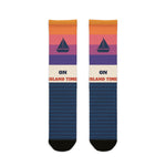 BlockBoundRI On Island Time Block Island socks with sunset stripes, navy sailboat and navy wave pattern, flat lay