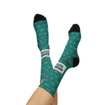 Model's legs crossed in the air wearing teal Quahog Squad Rhode Island socks, clam print soles and band in view