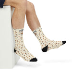 Close side view of raised feet in cream Powered by Coffee Milk Rhode Island socks with black toes
