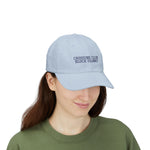 Woman in a green tee wearing the Light Blue Crossing Club Block Island hat, front view of embroidery