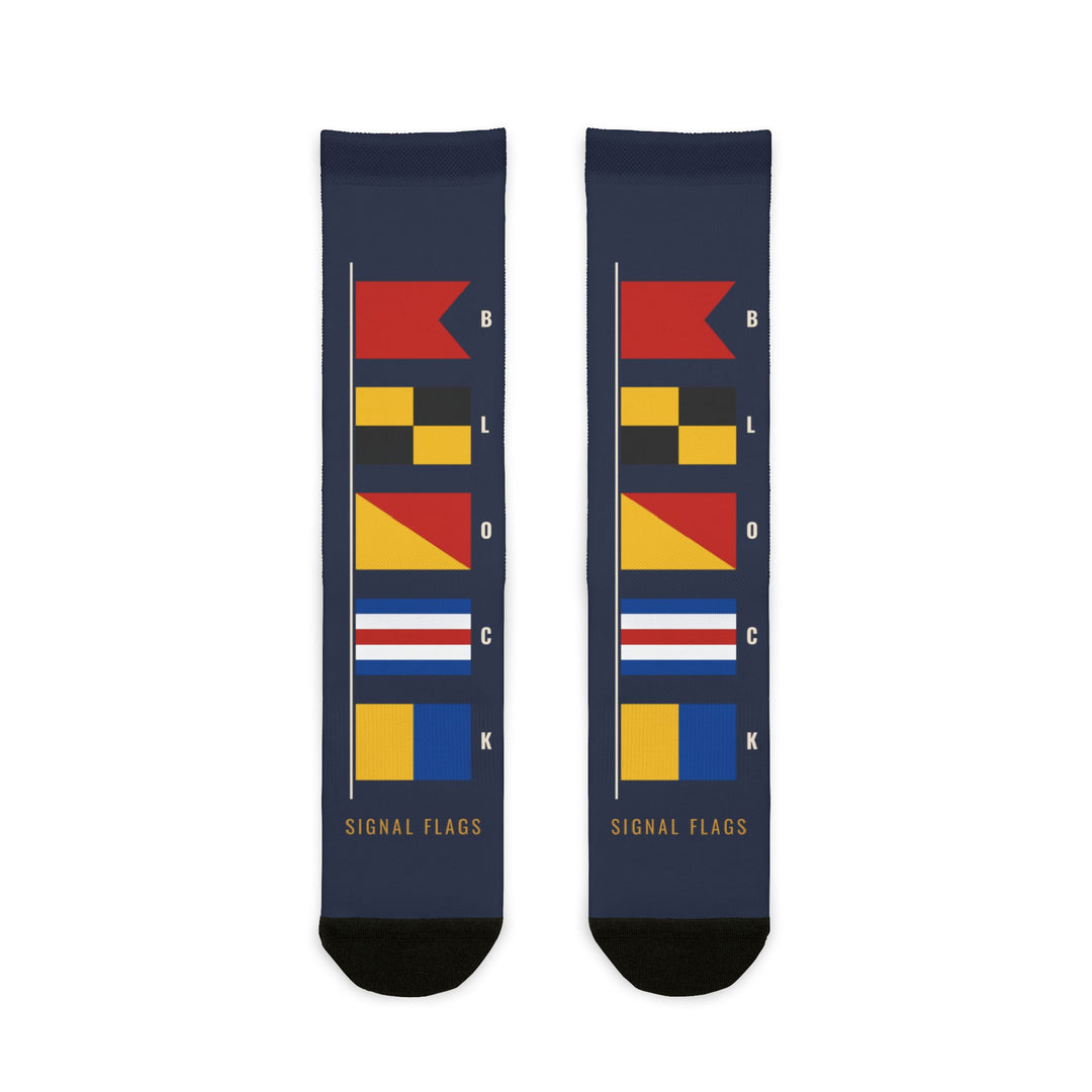 BLOCK ISLAND signal flag socks laid flat: navy crew socks with a column of colorful nautical flags and black toes