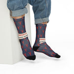 Model in rolled jeans seated on a white block wearing Property of Block Island lobster Rhode Island socks