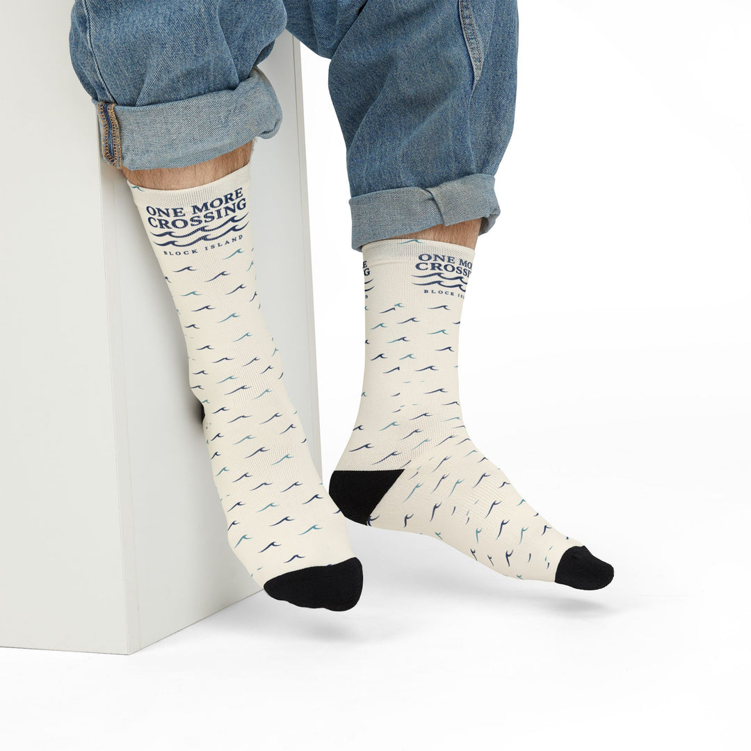 Model in rolled jeans seated on a white block wearing off-white Block Island wave socks with black heels