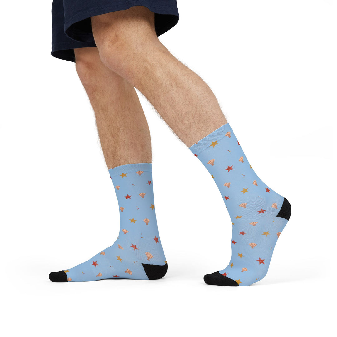 Mid-stride model in shorts wearing Beachcomber light blue starfish and shell beach socks