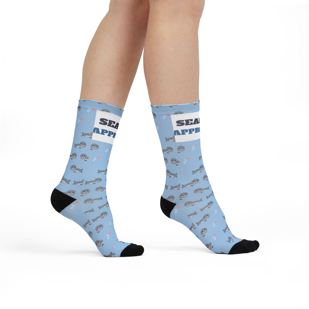 Model walking in light blue Seal of Approval Rhode Island socks with gray seals and black toes, side view