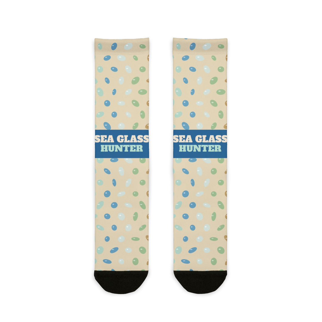 BlockBoundRI Sea Glass Hunter socks flat lay, sand-colored crew socks with blue band and scattered sea glass print