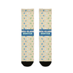 BlockBoundRI Sea Glass Hunter socks flat lay, sand-colored crew socks with blue band and scattered sea glass print